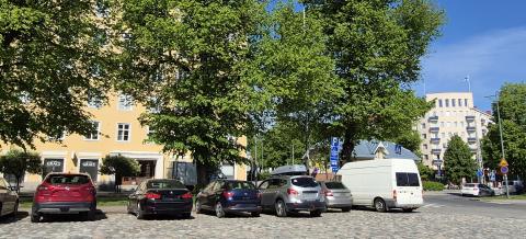 Pyynikintorin nupukivinen parkkipaikka isojen puiden edessä kesällä.