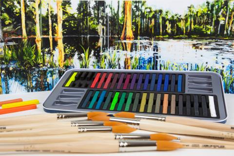 Puuvartisten taiteilijasiveltimien takana on värikkäitä liituja.