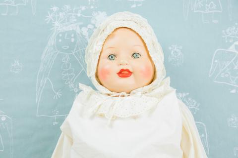 Vanha nukke valkoiset röyhelövaatteet yllä.