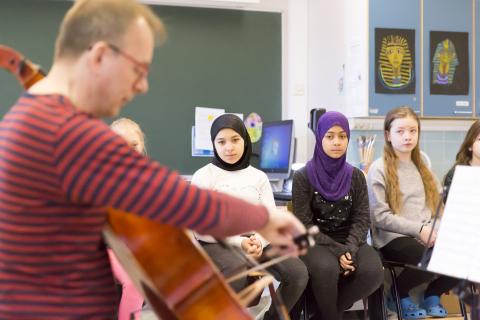 Lapset kuuntelevat, kun sellisti soittaa luokassa.