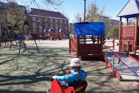 Etualalla lapsi jousikiikussa ja esteetön monitoimilaite.