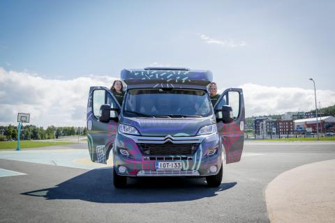 Kaksi ihmistä katsoo ulos matkailuautosta.