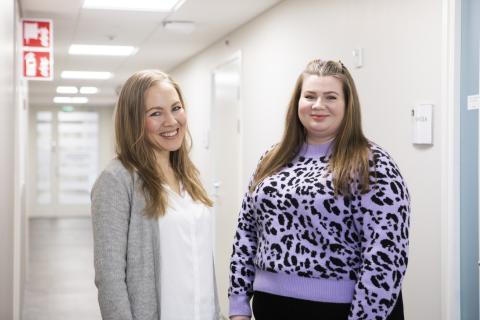 Kaksi sosiaalityöntekijää seisoo työpaikkansa käytävällä.