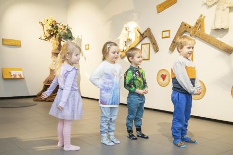 Lapset seisovat jonossa ja katsovat seinällä olevia taideteoksia