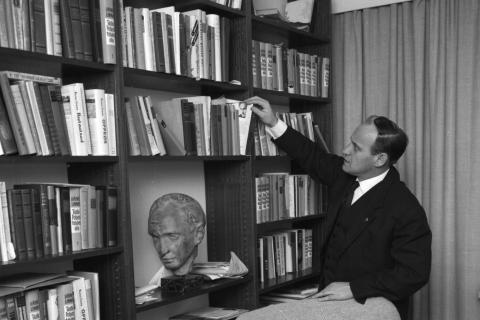 Väinö Linna katselee kirjoja kirjahyllystä.