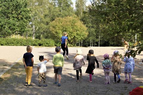 Liikunnanohjaaja leikittää lapsia puistossa.