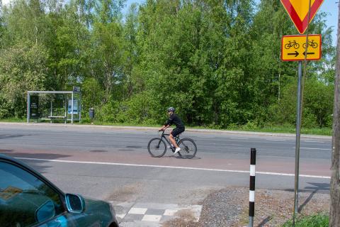 Auto väistämässä pyöräilijää ylijatketun pyörätien kohdalla
