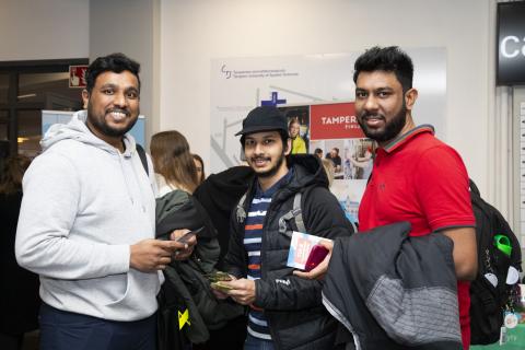 Kolme nuorta miestä katsomassa kameraan.