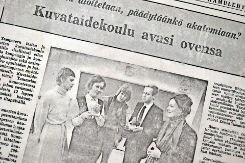 Lehtileike kuvataidekoulun avaamisesta. Keskellä kuva, jossa on ryhmä ihmisiä.