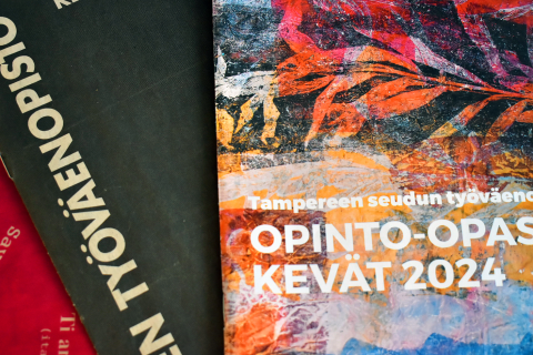 Työväenopiston kurssiesitteitä päällekkäin pöydällä.