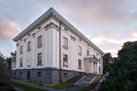 Pyynikinlinna, eli vaaleanpunainen kivirakennus valkoisin yksityiskohdin, kuvattuna kesäiltana alaviistosta.