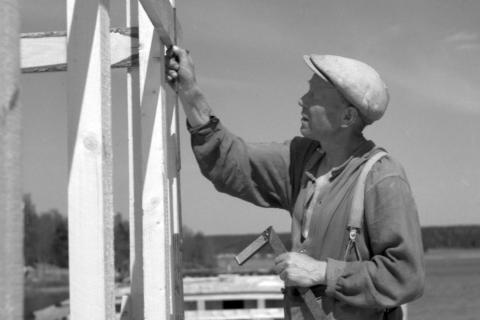 Rakennusmies mittailee lautarakenteita.