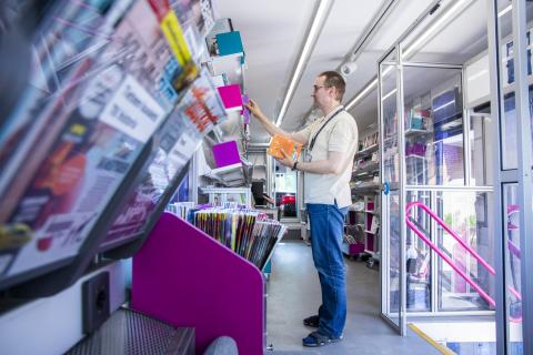 A man puts books into a shelf. 