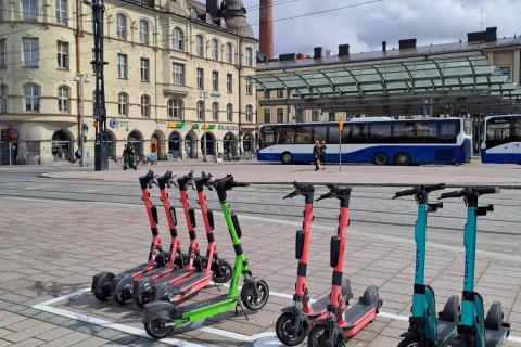 Sähköpotkulaudat rivissä sähköpotkulautojen pysäköintiruudussa.