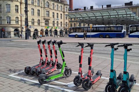 Sähköpotkulaudat rivissä sähköpotkulautojen pysäköintiruudussa.