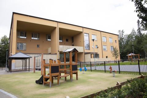 Eteläpuiston päiväkoti, etualalla leikkipaikka kiipeilytelineineen.