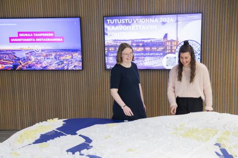 Vuorovaikutussuunnittelijat keskustan 3D-mallin äärellä. 