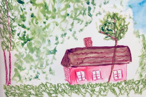 Maalattu punainen tupa vihreiden puiden katveessa.