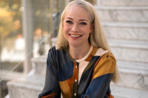 Hyvinvointilääkäri Pippa Laukka istuu rappusilla.