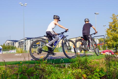 Poikia pyörineen pumptrack-radalla.