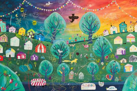 Maalattu yhteisötaideteos, jossa maisema värikkäine taloineen.