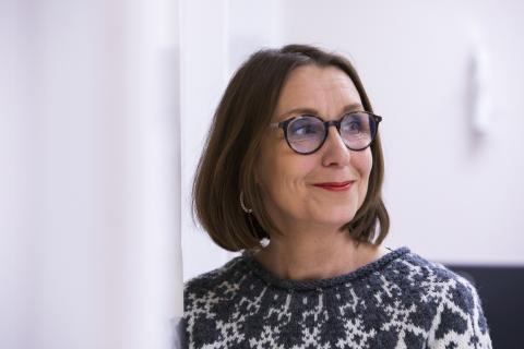 Person leans against the doorframe and looks to the side.