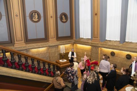 Lapsia Raatihuoneen rappusissa katselemassa seinällä olevia maalauksia.