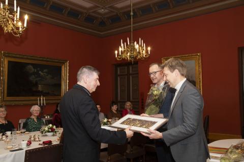 Apulaispormestari Matti Helimo ja sivistyspalvelujen johtaja Lauri Savisaari ojentavat Vuoden aikuinen -palkinnon Raatihuoneella.