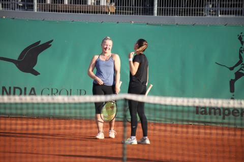 Tennispelaajia kentällä.