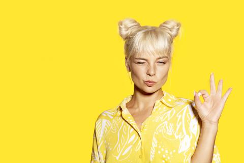 Kuvassa henkilö keltaisen taustan edessä