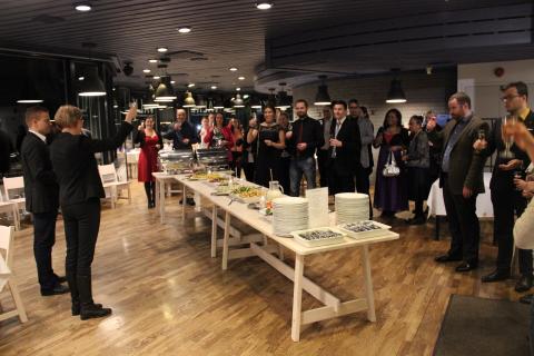 A person standing giving a speech in front of a audience.