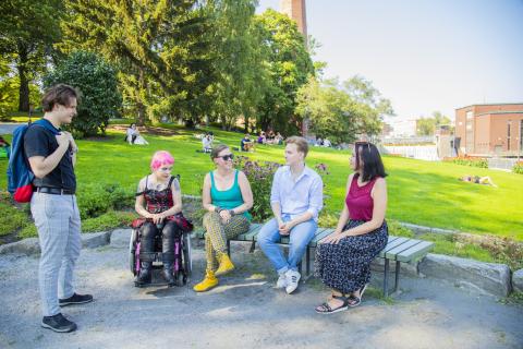 Viisi ihmistä puistossa.