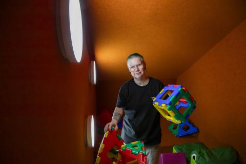 Varhaiskasvatuksen opettaja Ruska Lönn seisoo päiväkodin tiloissa käsissään isoja, värikkäitä rakennuspalikoita. 