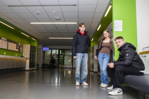 Opiskelijoita istuu ja seisoo Hervannan lukion käytävillä.