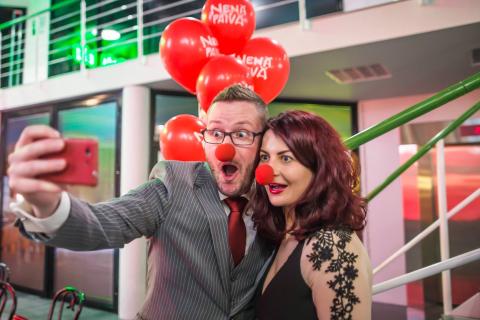 Two people with red noses taking a selfie.