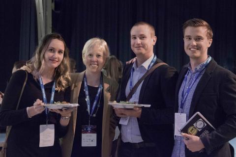 Group of four people posing together.