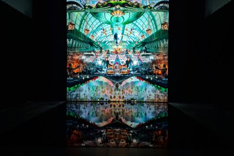 Pimeässä tilassa näkyy värikäs videokollaasi.