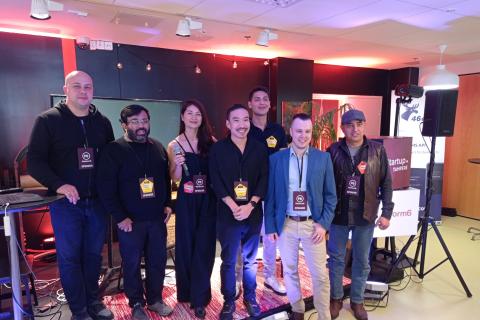 People posing in front of a stage.