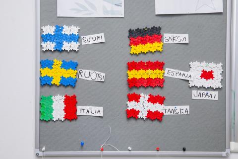 Ilmoitustaululla on eri maiden lippuja väripaloista koottuna.