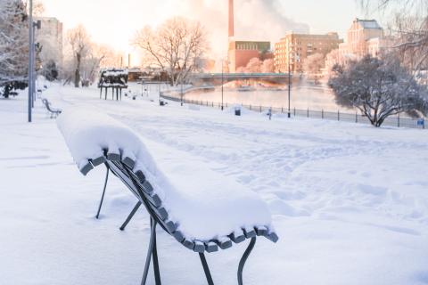 Talvinen maisema Koskipuistossa ja luminen penkki.