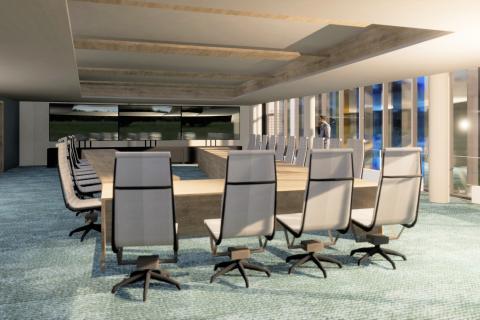 Havainnekuvassa on iso suorakaiteen mallinen pöytä, jonka ympärillä on tuoleja.