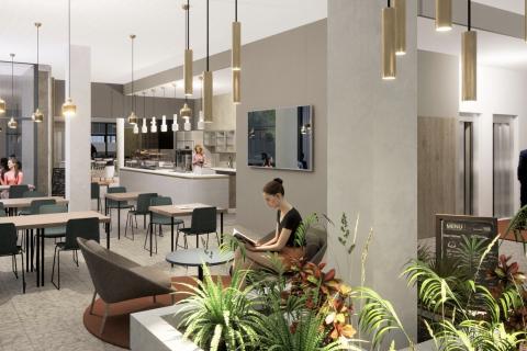 Havainnekuva kahvilan pöydistä ja etualalla olevasta kasvialtaasta, joka kiertää pylvästä.