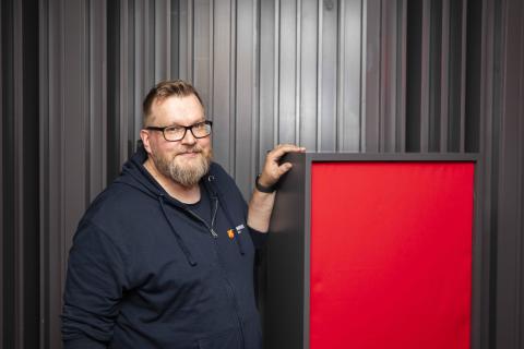 Teemu Haapakoski katsoo kameraan ja nojaa bassoansaan Monitoimitalo 13:n studiossa.