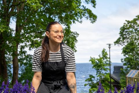 Enni Suihko istuu ulkona kivikaiteella Cafe Saran edessä.