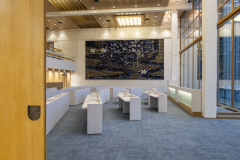 Sali, jonka liukuovi on raollaan. Salissa on paljon vaaleita pieniä pöytiä ja pylväiden välissä iso pöytä. Taustalla on iso keramiikkateos.