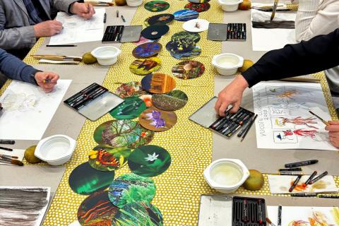 Ryhmä ikäihmisiä maalaa liiduilla luontokuvia.