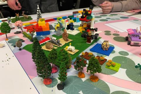 Rakennelma legoista, leikkipuista ja -eläimistä, joka kuvaa puistojoogaa Hakametsän ulkoalueilla.