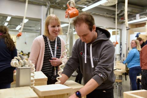 Kaksi henkilöä tekee linnunpönttöä yhdessä.