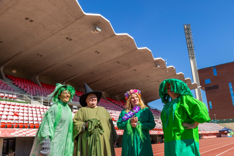 Mari Saari, Niina Toppari, Katja Hirvonen and Terhi Perttunen are dressed as forest elves in green forest outfits and standing on the running track at Ratina Stadium.