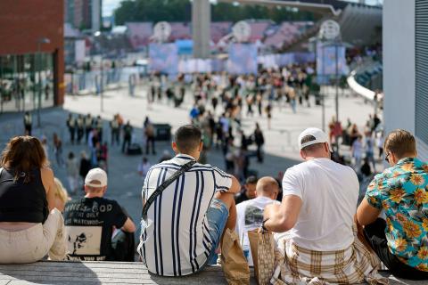 Ihmisiä kesäaikaan istumassa Ratinan Olympia-aukion portailla, taustalla Ratinan stadion.